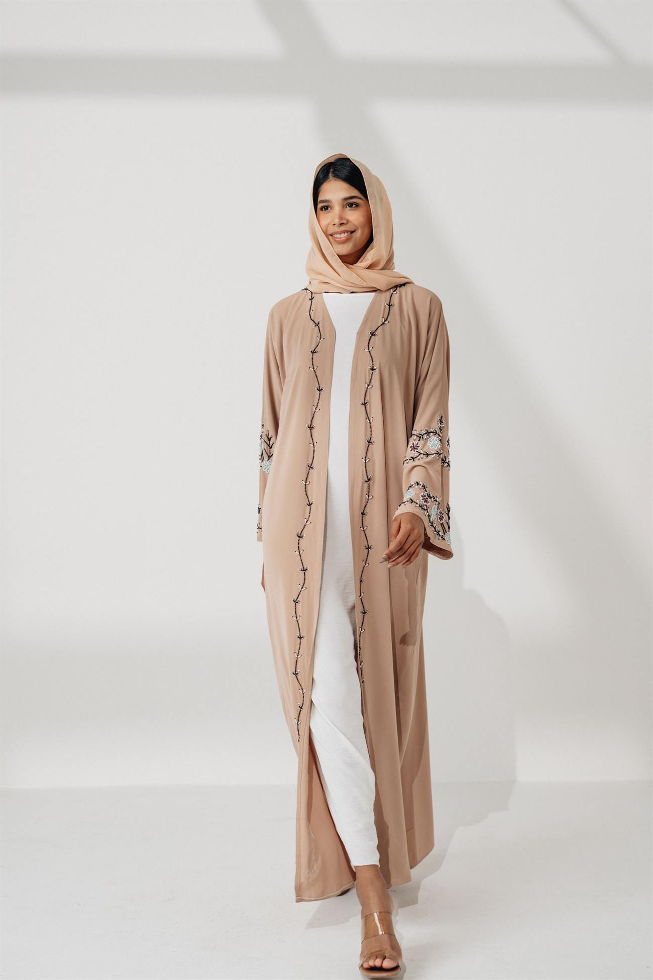 Model in a camel abaya with delicate embroidery