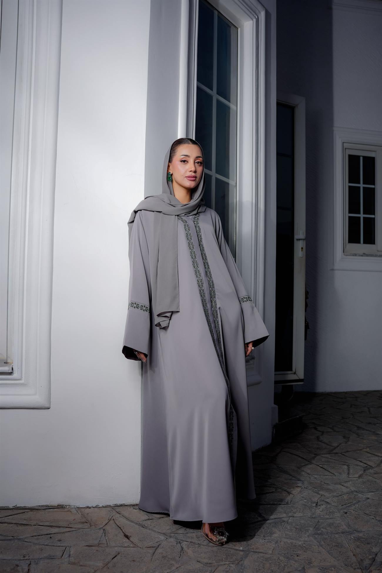 Model in a taupe abaya in a pale architectural setting